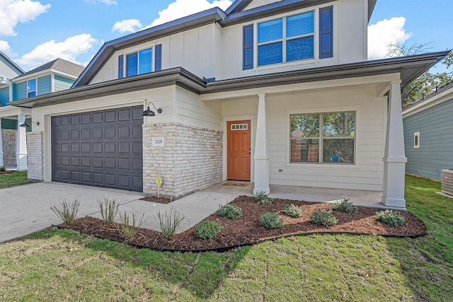 view of front of property featuring a garage, a front lawn, and covered porch