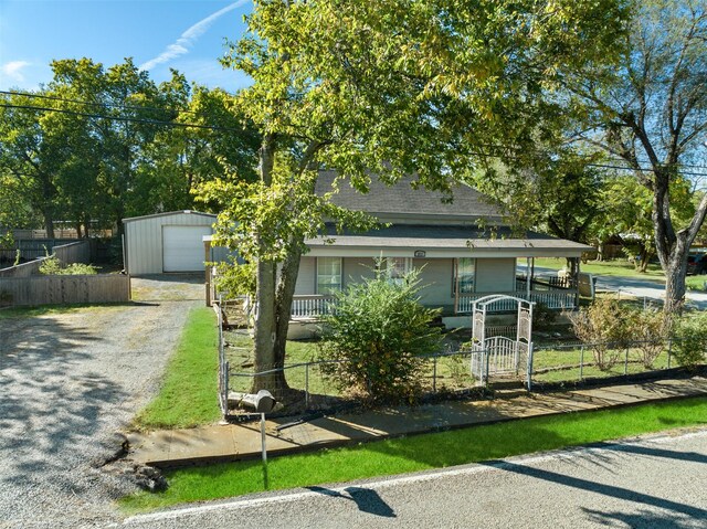 view of front of property featuring an outdoor structure, a porch, and a garage