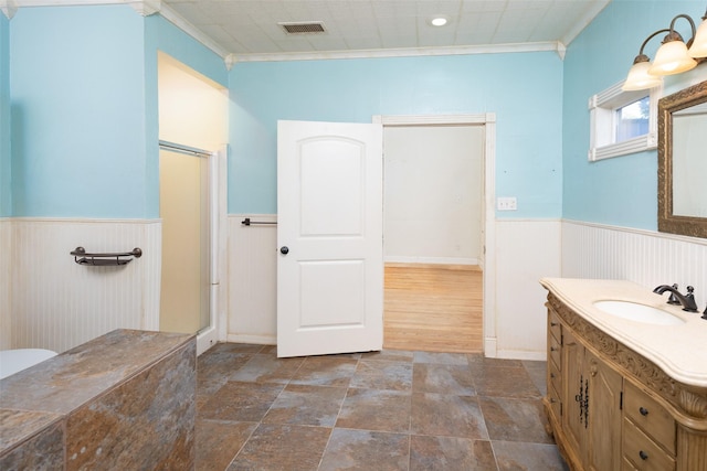 bathroom with vanity, an enclosed shower, and crown molding