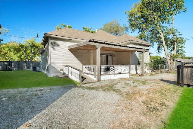 view of front of house with a front lawn and central air condition unit