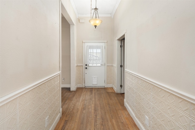 doorway to outside with hardwood / wood-style floors and ornamental molding