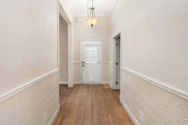 doorway with wood-type flooring and ornamental molding