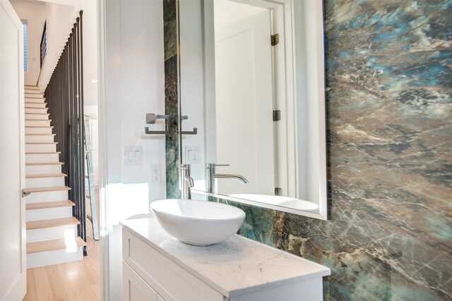 bathroom featuring vanity, decorative backsplash, and wood-type flooring