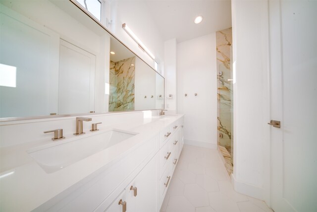 bathroom with vanity, a tile shower, and tile patterned floors