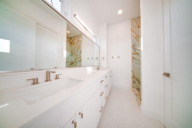 bathroom with double vanity, a sink, a marble finish shower, and tile patterned floors