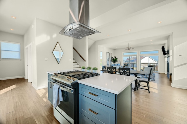 kitchen featuring island range hood, a center island, light hardwood / wood-style floors, high end stove, and a chandelier