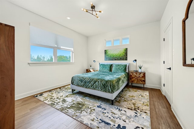 bedroom featuring a chandelier and wood-type flooring