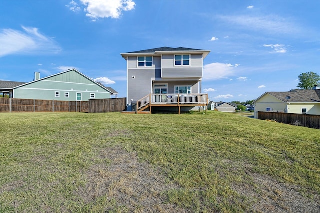 back of house featuring a deck and a lawn