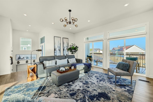 living room with light hardwood / wood-style flooring and a notable chandelier