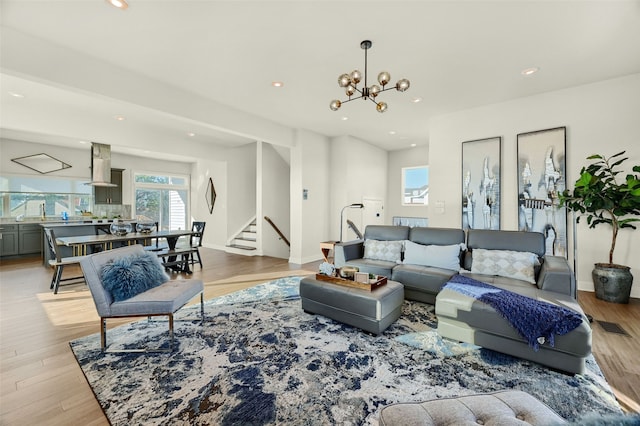 living room with an inviting chandelier and light wood-type flooring