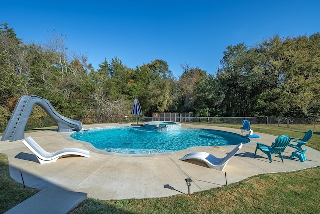 view of swimming pool featuring a water slide, a patio area, and an in ground hot tub