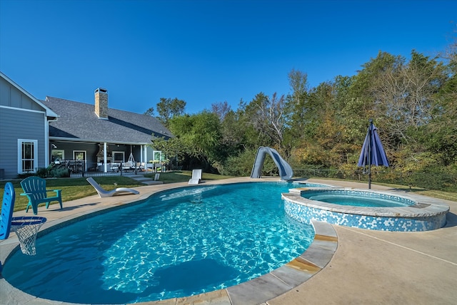 view of swimming pool featuring a water slide, an in ground hot tub, and a patio area