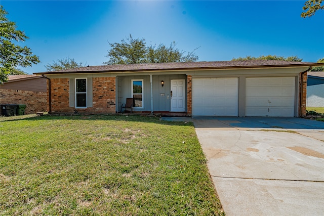 ranch-style house featuring a front lawn, covered porch, and a garage