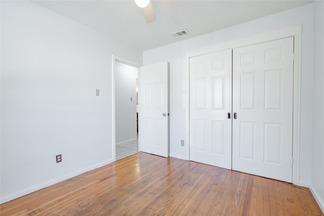 unfurnished bedroom with a closet, light hardwood / wood-style floors, a textured ceiling, and ceiling fan