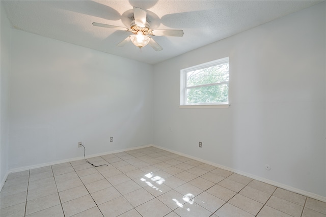 empty room featuring ceiling fan, a textured ceiling, and light tile patterned flooring