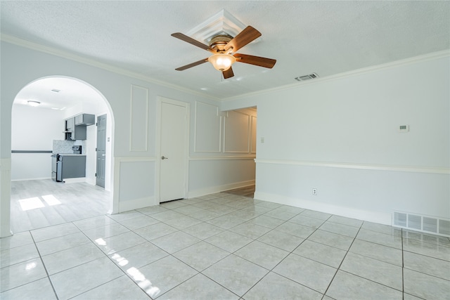 unfurnished room with crown molding, a textured ceiling, light tile patterned flooring, and ceiling fan