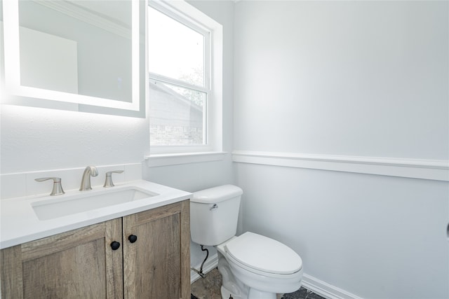 bathroom featuring vanity, crown molding, and toilet