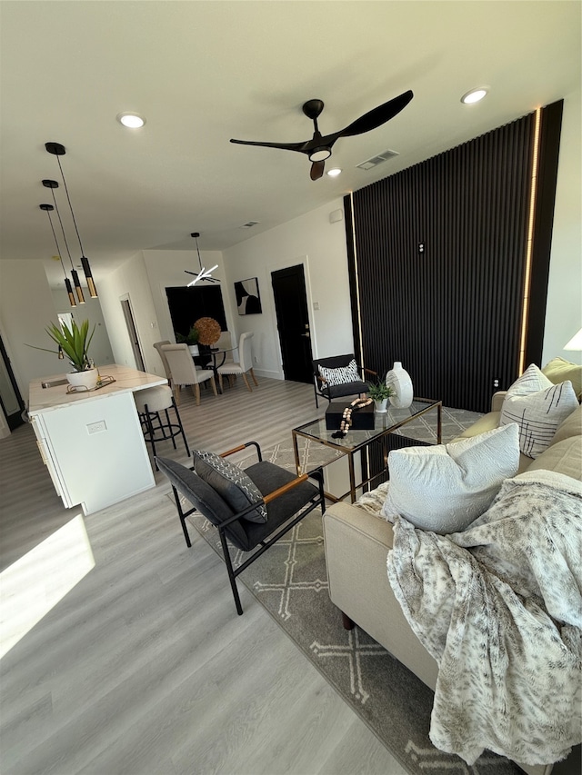 living room with light hardwood / wood-style flooring and ceiling fan