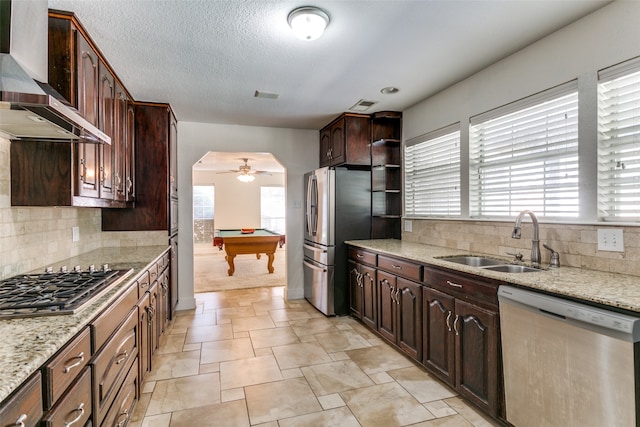 kitchen featuring appliances with stainless steel finishes, wall chimney range hood, sink, billiards, and ceiling fan