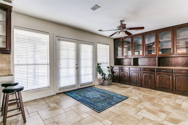 interior space featuring ceiling fan and a wealth of natural light