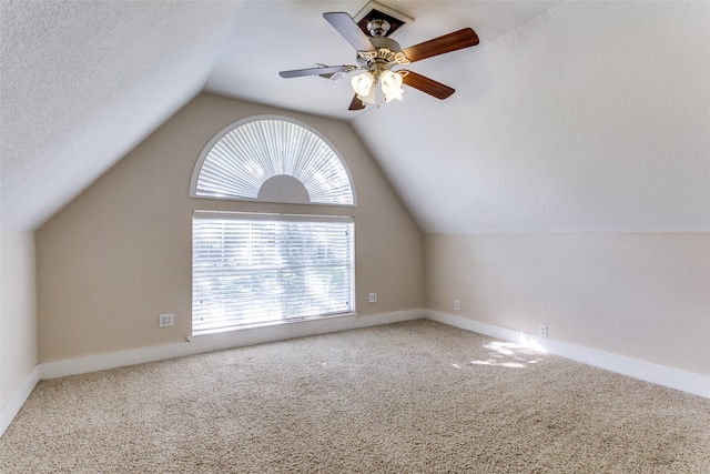 bonus room featuring ceiling fan, vaulted ceiling, a healthy amount of sunlight, and carpet flooring