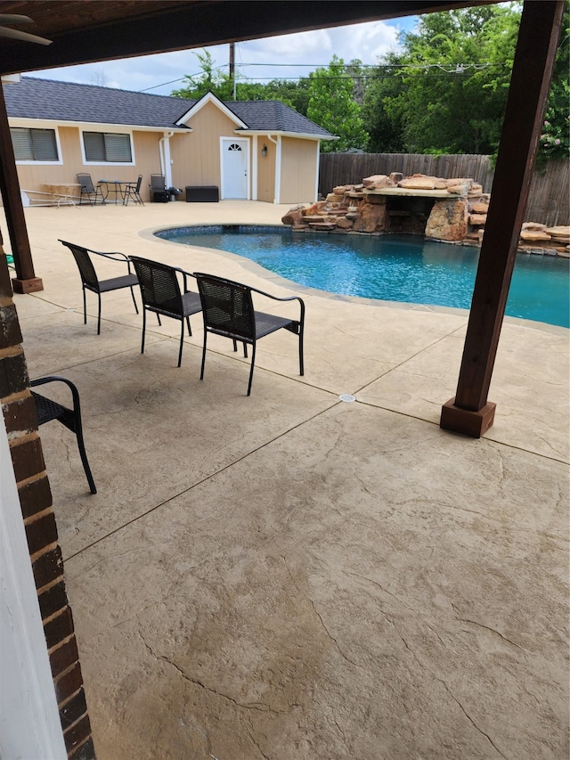 view of swimming pool featuring an outbuilding, pool water feature, and a patio