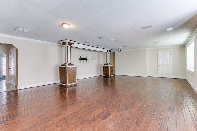 unfurnished living room featuring dark hardwood / wood-style flooring and crown molding