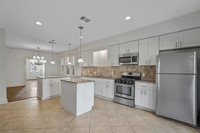 kitchen featuring a kitchen island, hanging light fixtures, kitchen peninsula, stainless steel appliances, and white cabinets