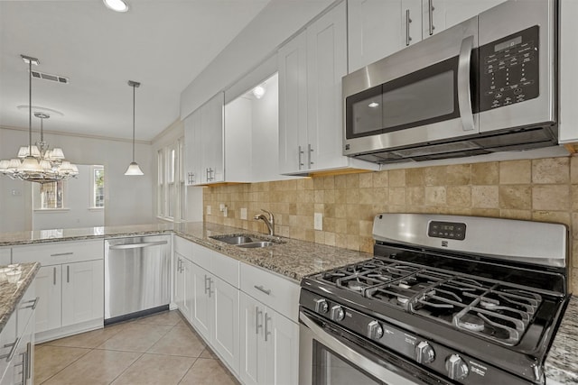 kitchen with light stone countertops, sink, white cabinetry, stainless steel appliances, and light tile patterned floors