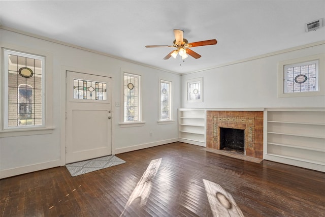 unfurnished living room featuring a tiled fireplace, ornamental molding, dark hardwood / wood-style floors, and ceiling fan