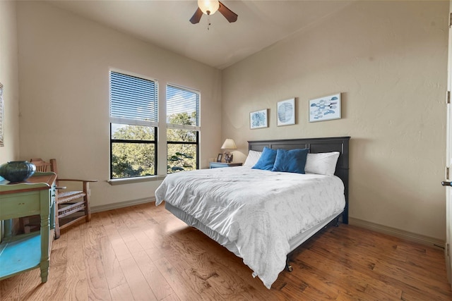 bedroom featuring ceiling fan, hardwood / wood-style flooring, and vaulted ceiling