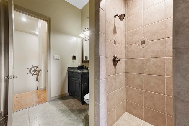 bathroom featuring vanity, toilet, wood-type flooring, and tiled shower