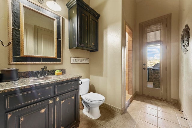 bathroom featuring vanity, toilet, tile patterned floors, and a shower