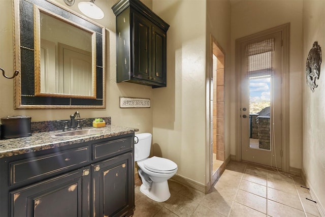 bathroom with toilet, tile patterned floors, baseboards, a shower stall, and vanity
