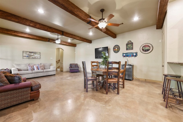 dining area featuring beamed ceiling and ceiling fan