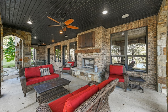 view of patio with ceiling fan and an outdoor living space with a fireplace