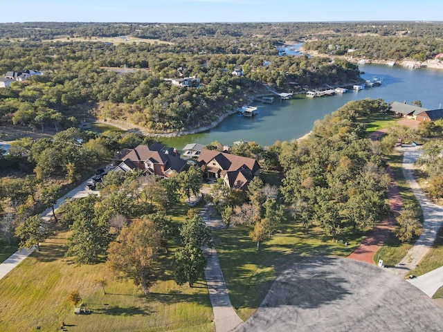 birds eye view of property with a wooded view and a water view