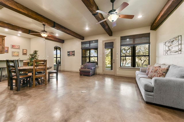 living room with beamed ceiling, concrete flooring, and ceiling fan