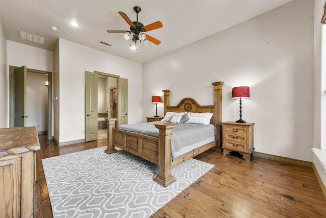 bedroom with hardwood / wood-style flooring, connected bathroom, baseboards, and visible vents