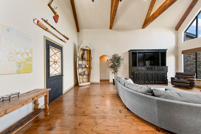 living room with high vaulted ceiling, wood finished floors, beamed ceiling, and arched walkways