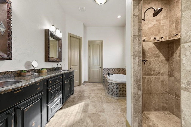 full bathroom featuring visible vents, a sink, a tile shower, a garden tub, and double vanity