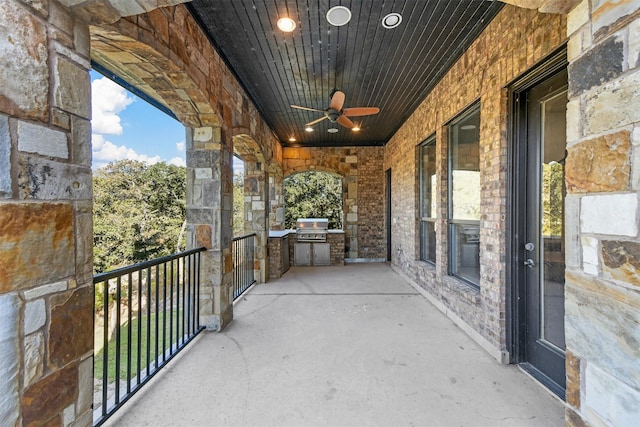 balcony with grilling area, an outdoor kitchen, and ceiling fan