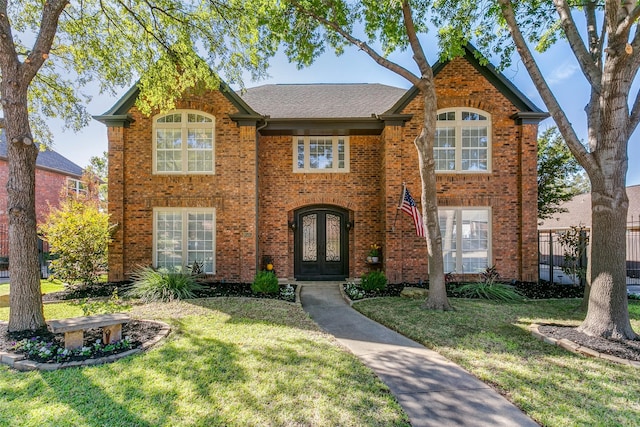 view of front of home with a front yard and french doors