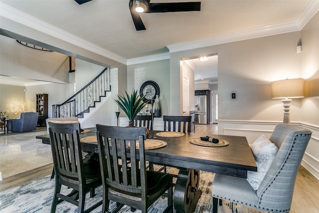 dining room featuring light hardwood / wood-style floors, ceiling fan, and crown molding