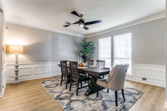 dining space featuring hardwood / wood-style flooring, ceiling fan, and crown molding