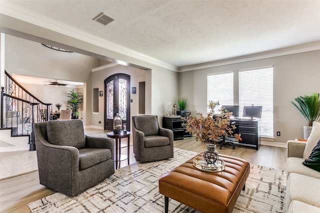 living room with ceiling fan, light hardwood / wood-style floors, a healthy amount of sunlight, and a textured ceiling