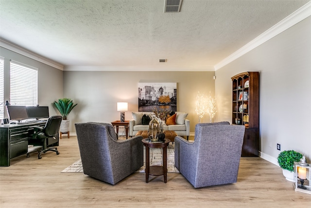 living room featuring crown molding, light hardwood / wood-style flooring, and a textured ceiling