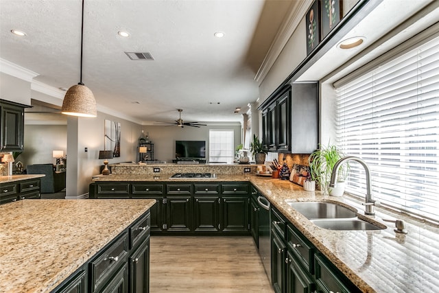 kitchen featuring light stone countertops, sink, ceiling fan, stainless steel appliances, and decorative light fixtures