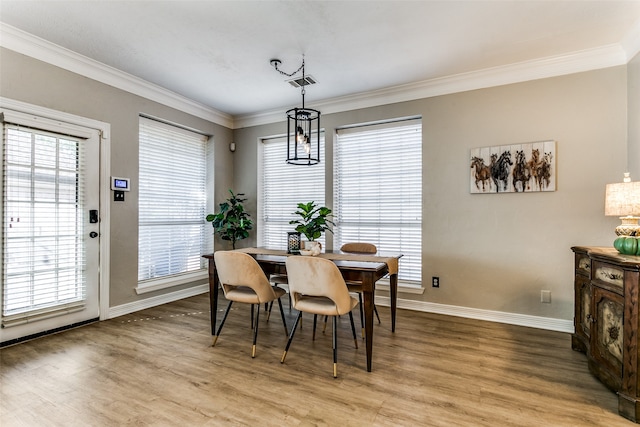 dining space featuring wood-type flooring and ornamental molding