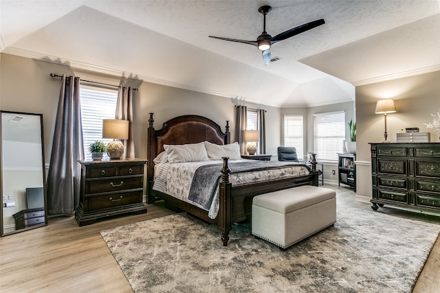 bedroom with hardwood / wood-style floors, ceiling fan, multiple windows, and vaulted ceiling